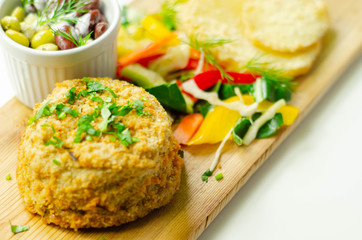 Smoked haddock fishcake with slices fried potatoes and mixed salad