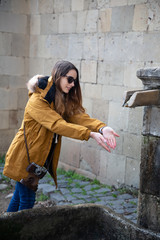 Photo of young tourist girl exploring streets of Baku. Moody photos of teenager girl visiting old city and taking photos of the city