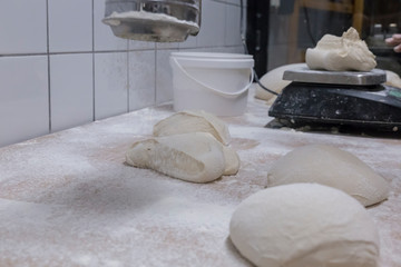 Pouring flour to the bread loafs before entering them in the oven