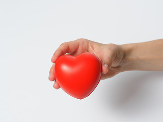 Red heart in a woman's hand on a white background. The concept of charity. helping loved ones