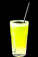 Green smoothie made from herbs and vegetables in a large glass glass on a black background, isolated