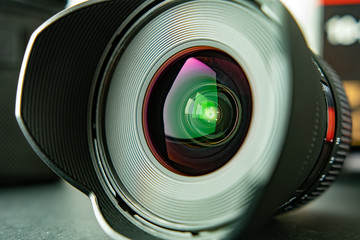 Close up photography of wide angle lens with reflections in the glass and hood attached