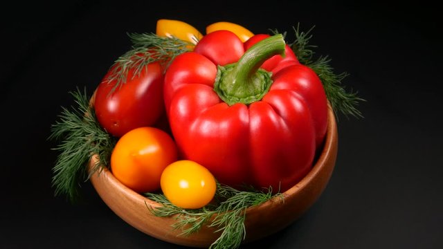 Yellow and red tomatoes, sweet peppers and greens for salad preparation
