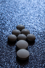 White pills, tablets capsule form an arrow on a dark shiny background