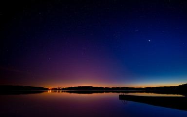 Late sunset on the lake. Beautiful night starry sky.