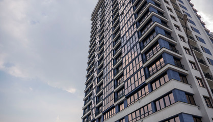 Obraz premium building facade reflection in glasses against the sky