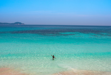 mujer en playa paradisiaca de malasia (Perhentian) mirando al horizonte