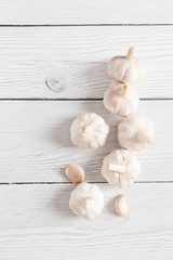 Garlic cloves on white wood background as copy space