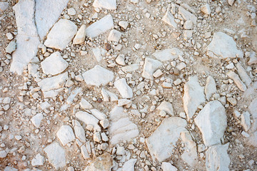 Stony soil. Natural background beige color. Natural stones of different shapes and sizes. There are...
