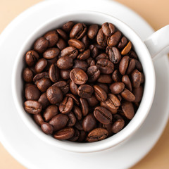  Close-up of a white mug with coffee beans arabica. 