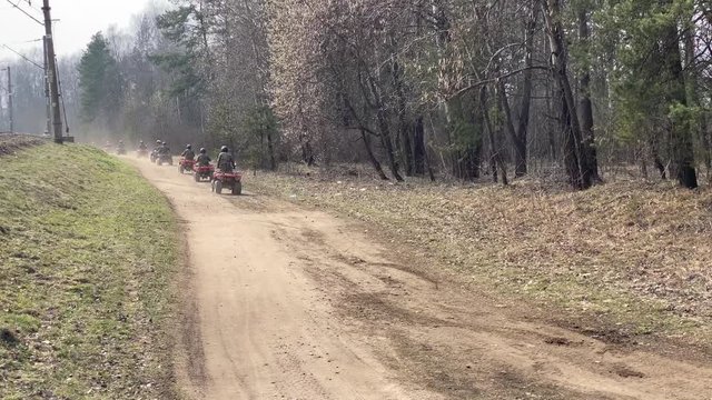 A row of ATV going on forest road