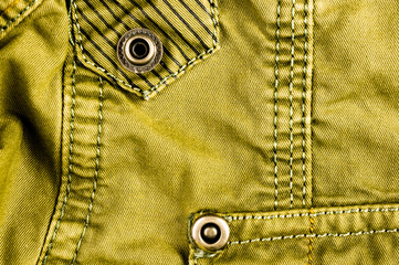 clothing items stonewashed cotton fabric texture with seams, clasps, buttons and rivets, macro