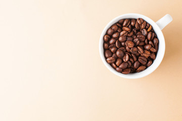  White mug with arabica coffee beans in the upper corner of a horizontal photo, a lot of space for text. 