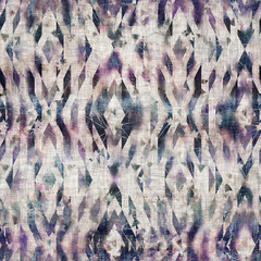 Seamless mixed media collage design in old aged worn look. Ethnic tribal boho kilim rug design overlaid, mottled, and distressed on fabric texture. Seamless repeat raster jpg pattern swatch.