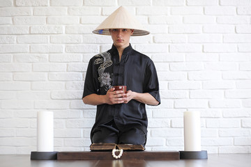 Asian young novice on a white brick wall