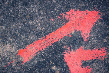 red direction arrow on gray concrete