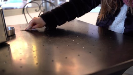 Unrecognizable female person wiping iron table with paper towel at the bar outdoors, morning customer cleaning dirty table from food remnants, hygiene and sanitation in public places. Microbe and - Powered by Adobe