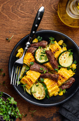 Beef salad with corn, zucchini and micro greens on a wooden table. Healthy food. Top view