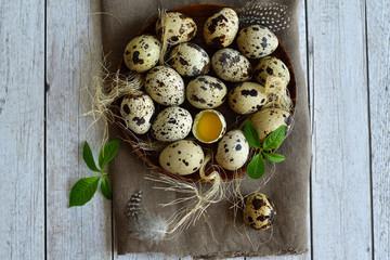 quail feathers and eggs on a brown linen napkin. Copy space for greeting text, Happy Easter card, top view.