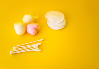 cotton swabs, colored cotton wool ball, cotton discs Yellow background. Free copy space. Hygiene