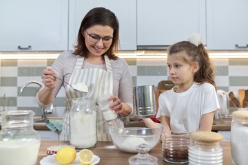 Mother and child preparing bakery together in home kitchen