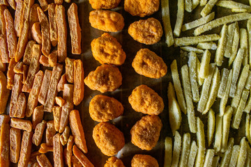 Fast food preparing at home, french fries, chilli bites and sweet potato fries before throwing them to the oven for dinner, frozen food prepping, student diet with no efford.