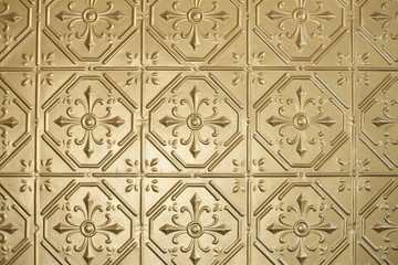 Brass or gold painted decorative pressed metal wall. Retro, vintage wall panelling. 