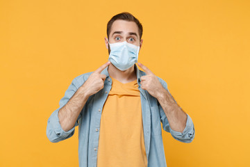 Young man in casual clothes posing isolated on yellow background studio portrait. Epidemic pandemic...