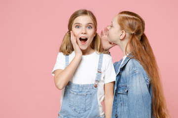 Shocked little kids girls 12-13 years old in white t-shirt, denim clothes isolated on pink...