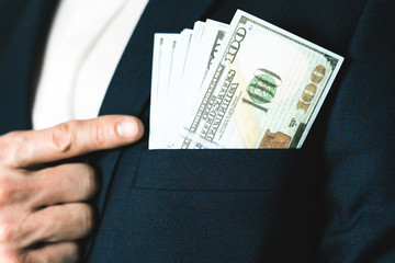 Money success concept. 100 dollar bills in businessman jacket pocket. Symbol of success and wealth.