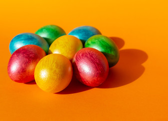 Colorful easter eggs on orange background. Happy Easter composition. Copy space.