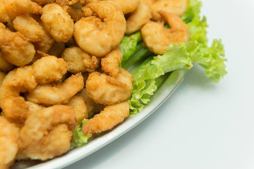 Closeup of delicious deep fried shrimps served with lime wedges and lettuce leaves