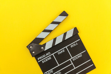 Fototapeta na wymiar Filmmaker profession. Classic director empty film making clapperboard or movie slate isolated on yellow background. Video production film cinema industry concept. Flat lay top view copy space mock up.