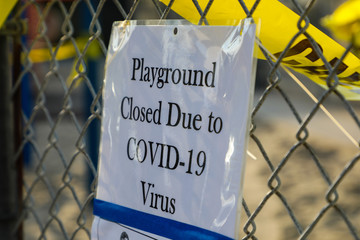 Playground closed due to COVID-19 sign on chain link fence