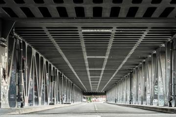 Urban street under a steel bridge.
