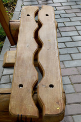 An unusual wooden bench consisting of two halves, symbolizing the two principles of male and female, good and evil.