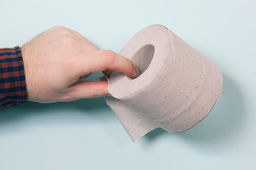 toilet paper in male hand on blue background