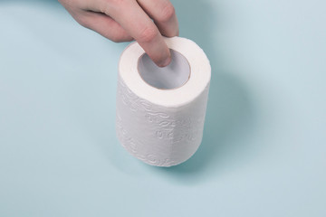 toilet paper in male hand on blue background