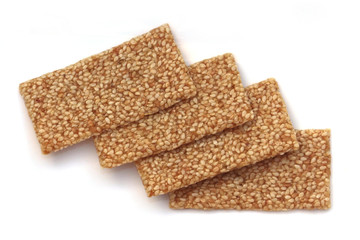 Four sesame seed snaps laid over each other at angles on a white background