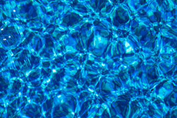 Blue background with lots of light spots. Sun glare in the pool	