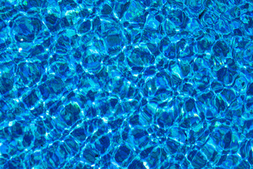 Blue background with lots of light spots. Sun glare in the pool	
