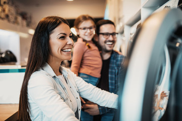 Happy family buying washing machine in store.