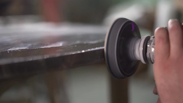 Male Worker's Hand Uses Electric Tool To Polish a marble table at the factory. Super Slow Motion