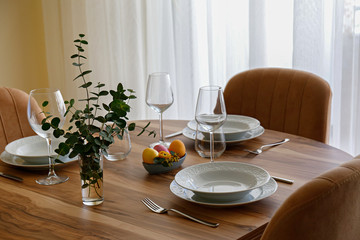 Easter table setting composition with traditional golden painted egg, beautiful tableware on natural dark wood textured table. Top view, copy space, close up, background.