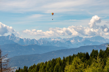 Panorama of the Austrian Alps,Europe,at Lake Ossiacher See with the mountains of the Karawanken Mountains with paragliders