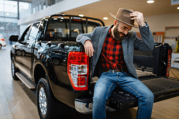 Happy man poses in the back of new pickup truck