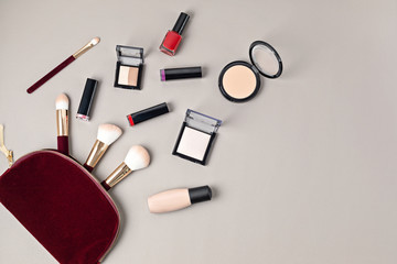 Flat lay with set of professional decorative cosmetics, makeup tools and woman accessories over gray background with copy space. Beauty blog, fashion, party and shopping concept