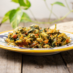 Mexican scrambled eggs with spinach on wooden background