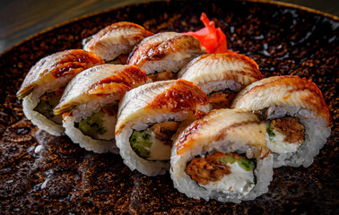 sushi roll with cream cheese and eel in plate on wooden table background