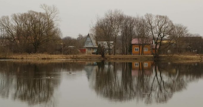 Small pond and old houses in the suburbs near Leningradskoye Shosse